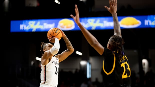 Cincinnati Bearcats guard Jeremiah Davenport (24) hits a 3-pointer over East Carolina Pirates forward Brandon Johnson (23) in the first half of the NCAA men's basketball game between the Cincinnati Bearcats and the East Carolina Pirates on Wednesday, Jan. 12, 2022, at Fifth Third Arena in Cincinnati. East Carolina Pirates At Cincinnati Bearcats 95